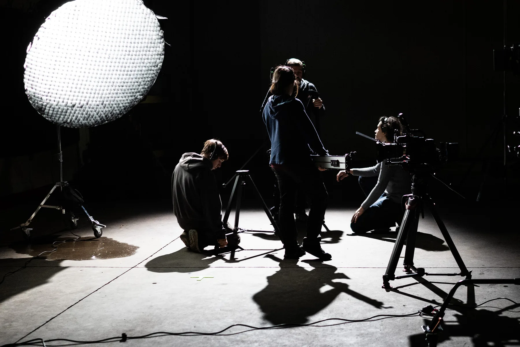 Wide shot of the film set with crew and lighting balloon